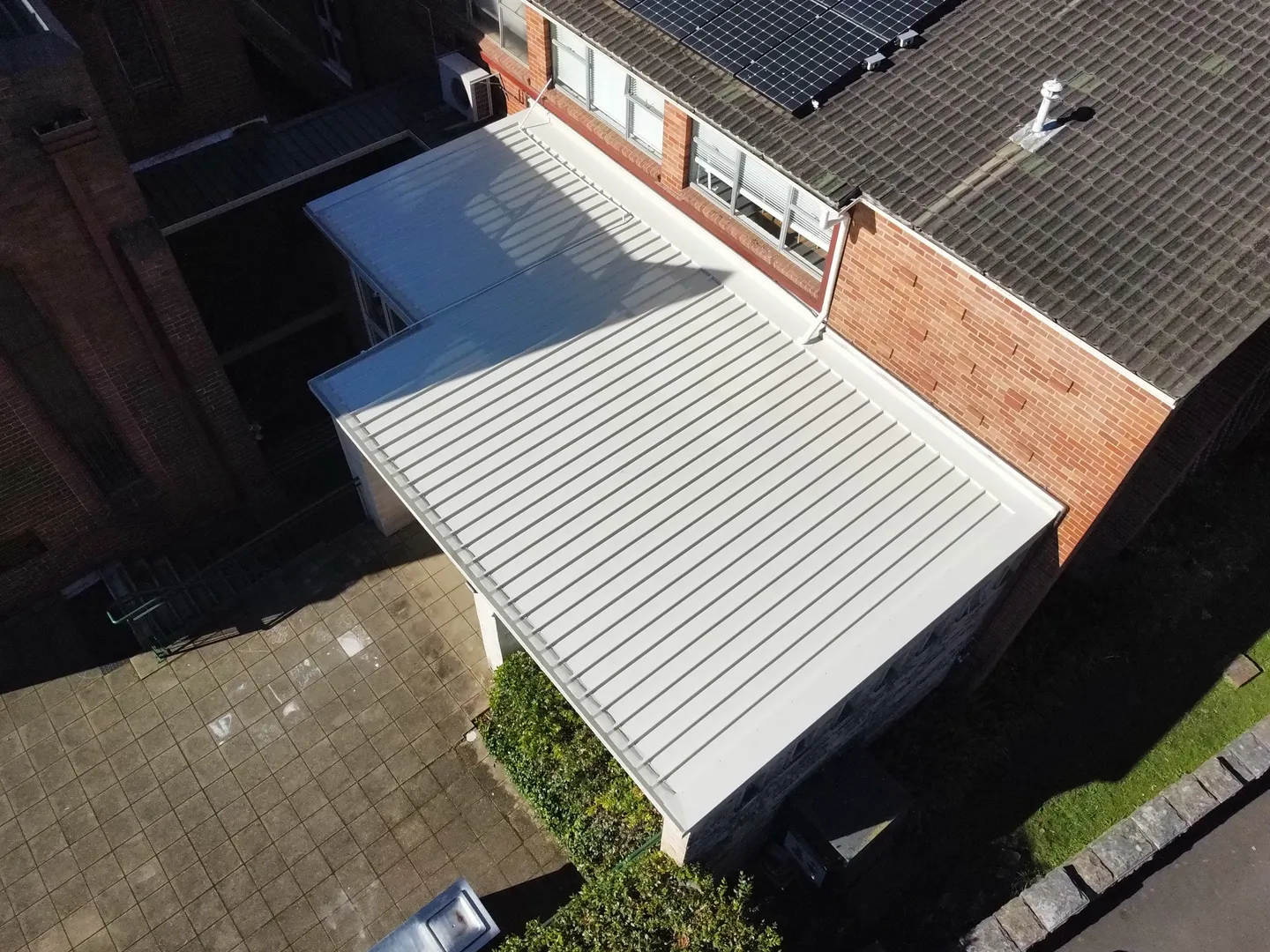 Aerial view of building roof with solar panels.